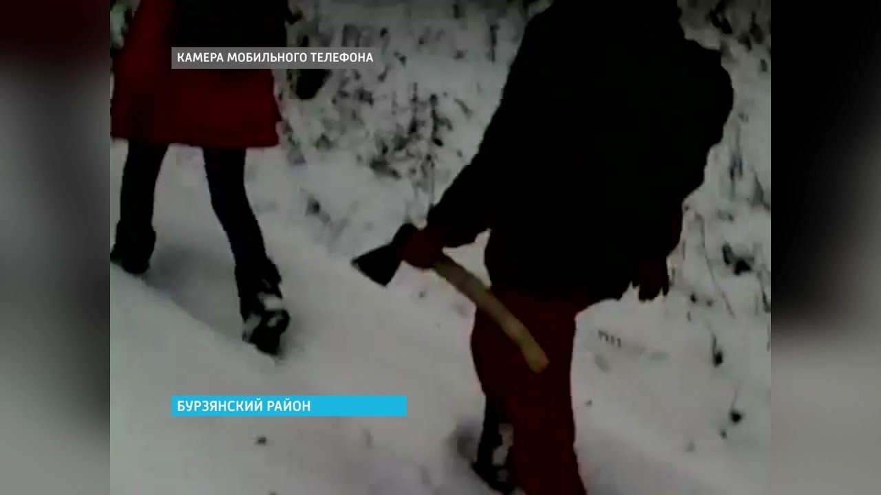 Two people walking down a snowy path with an axe.