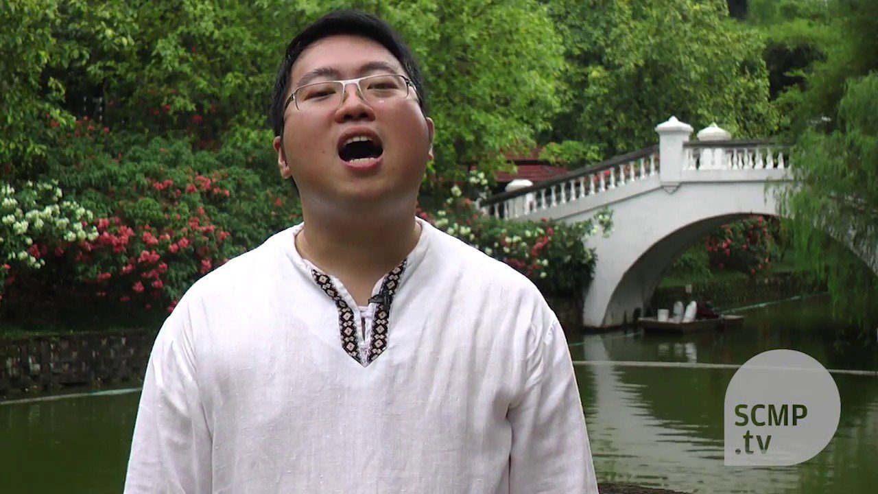 A man is singing in front of a pond.