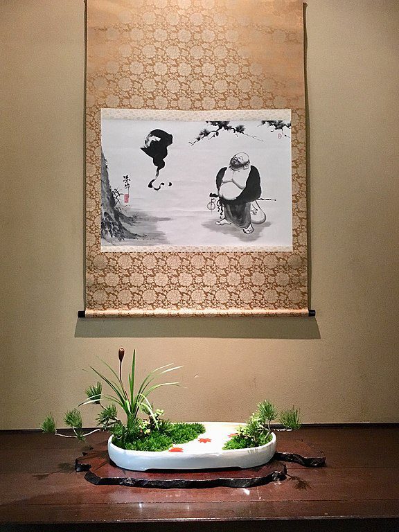 An autumnal Moribana (盛花) as a river landscape in front of a picture scroll in a tokonoma (床の間), from the Ohara-ryū (小原流) in the Chōjō no ma (頂上の間). 57 different schools of Ikebana belonging to the largest Ikebana organization in Japan, the “Public Interest Incorporated Foundation Japan Ikebana Art Association” (公益財団法人日本いけばな芸術協会), presented their works in exhibitions at the Meguro Gajoen that changed weekly. From the traditional arrangements with flowers and fruits that embody autumn colors to the dynamic free-style arrangement that utilized the entire room, works from various schools were shown in one exhibition. (Photo: Wikimedia/Gryffindor)