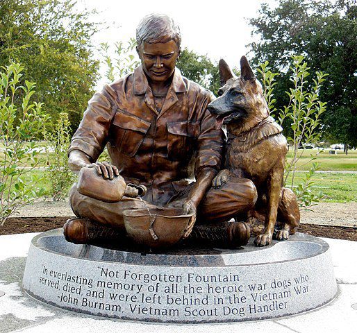 The "Not Forgotten Fountain" is a bronze sculpture depicting a Vietnam War dog handler pouring water from his canteen into a helmet. The sculpture represents a Vietnam era dog handler and his working dog. The water fountain is fully functional so that a visiting dog may have a drink. (Photo: Wikimedia/