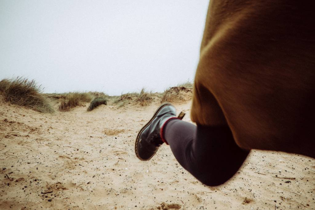 One leg in boots while running (Photo: Unsplash/Mitchell Orr)