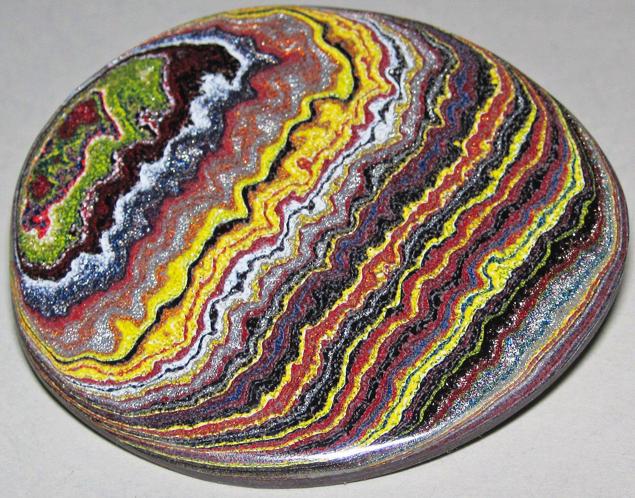 Fordite is a lapidarist's term for polished pieces of finely-layered, multicolored paint masses derived from painting rooms in automobile factories. The name is in reference to the <a href=