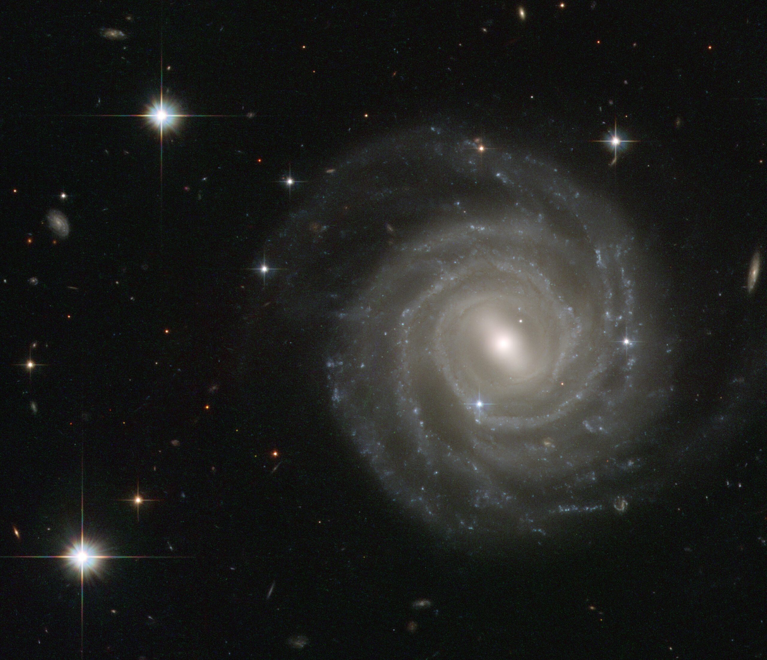 The galaxy captured in this image, called UGC 12158, is posing face-on to the NASA/ESA Hubble Space Telescope’s Advanced Camera for Surveys, revealing its structure in fine detail.