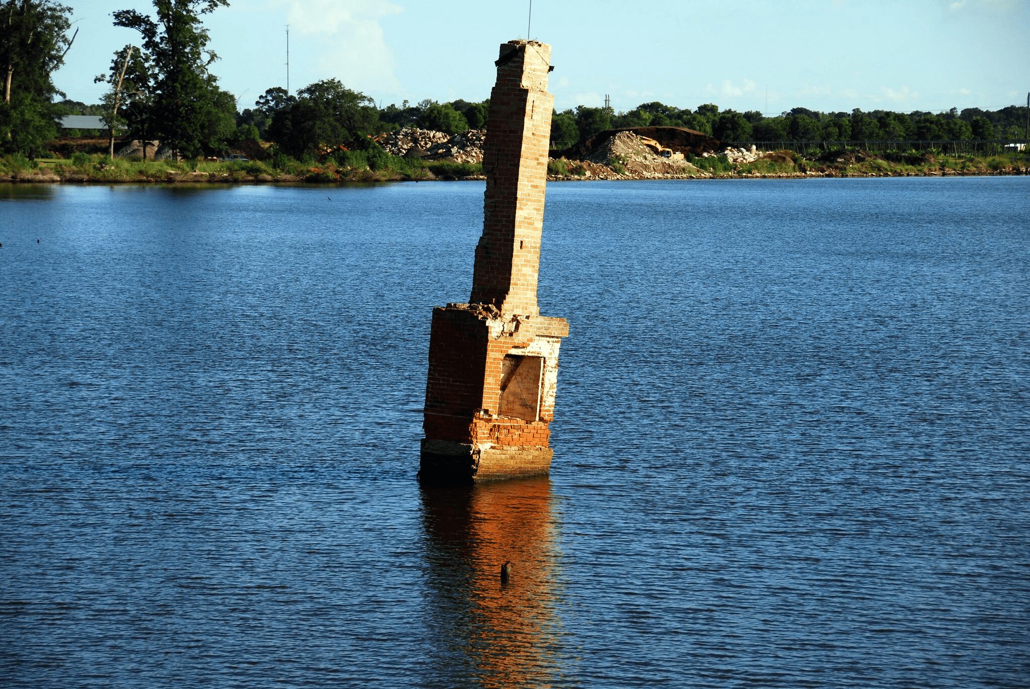 Years later, a lone chimney emerges from the water where a house once stood. 